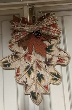 a door hanger decorated with fall leaves and burlocked in jute