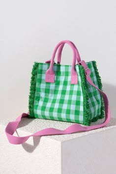 a green and white checkered bag with pink handles