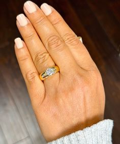 a woman's hand with a gold ring on it and a diamond in the middle