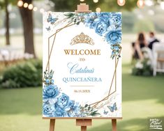 a welcome sign with blue flowers on it in front of an outdoor dining area at a wedding