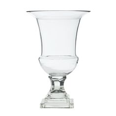 a clear glass vase sitting on top of a white table next to a silver base