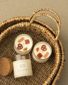 three candles sitting on top of a wicker basket