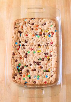 a cookie cake in a plastic container on top of a wooden table