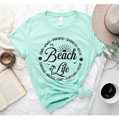 Beach Life T-Shirt, Beach Shirt, Beach Shirt, Beach Vibes Shirt, Beach Days T-Shirt, Bestie Beach Shirt, Summer Tee, Summer beach shirt How to Order?  1-Choose your t-shirt color, 2- Choose your size, 3- Select the quantity, 4- Click Add to Cart.  Production and shipping: * 100% airlume combed and ring-spun cotton, 32 singles 4.2 oz. * Solid colors are %100 cotton * Heathers are %52 cotton %48 polyester * Athletic Heather is combed and ring-spun cotton, 10% polyester * Seamless collar * Heat tra Beachwear T-shirt With Graphic Print For Summer Adventures, Tropical Graphic Print T-shirt For Beach, Green Letter Print T-shirt For Vacation, Summer Beach Camp Shirt With Graphic Print, Beach Camp Shirt With Palm Tree Print, Summer Camp Shirt With Graphic Print For Beach, Beachy Vacation Shirt, Beachy Shirt For Beach Party, Vacation Beach Camp Shirt With Palm Tree Print