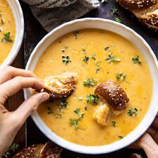 two bowls of soup with bread on the side