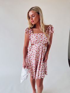 DETAILS: Our Olivia Floral Cut Out Mini Dress is definitely a MUST HAVE for your wardrobe this spring and summer! This dress features a floral pattern, side cut outs, flowy skirt (that is lined), self tie adjustable shoulder straps, self tie back detail, and has a hidden back seam zipper closure with a hook and eye clasp. CONTENT & CARE: SELF: 100% Cotton. LINING: 100% Rayon. SIZE & FIT: Model is 5'5" The model is wearing a size small Fits true to size The Fabric has stretch Summer Sundress With Ditsy Floral Print And Square Neck, Spring Sundress With Tie Straps For Day Out, Summer Floral Square Neck Dress For Brunch, Beach Sundress With Knotted Straps For Spring, Floral Square Neck Sundress For Day Out, Summer Floral Dress With Square Neck For Brunch, Spring Dress With Adjustable Straps For Brunch, Square Neck Floral Sundress For Day Out, Spring Brunch Dress With Adjustable Straps