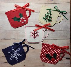 four christmas mugs are hanging on a wooden table with red and white polka dots