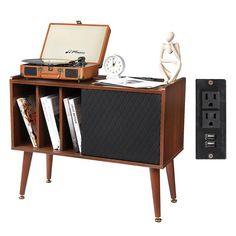 an old fashioned record player is sitting on a shelf next to a clock and other items