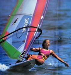 a woman riding a wind sail on top of the ocean