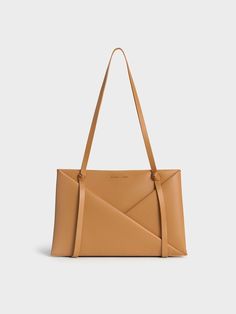 This product is made with at least 20% sustainable materials by weight. CHARLES & KEITH uses recycled, degradable, organic, and water-based materials in our eco-conscious collection. Immediately eye-catching, this Midori tote is a head-turner. The classic rectangular tote silhouette has been elevated with tasteful details -- geometric folds draw the eye to the luxurious camel finish, which is perfectly complemented by sculptural knots on the bag straps. Effortlessly elegant, the minimal design feature clean, flowing lines. Boasting a roomy interior, it will hold all that you need for the day and more. Complete with a detachable and adjustable strap for a hands-free option, this polished carrier strikes a balance between maximum function and visually appealing form. Black Saddle Bag, Chic Crossbody Bag, Stylish Purse, Classic Handbags, Luxury Bag, Charles Keith, Zip Wallet, Everyday Bag, Sustainable Materials