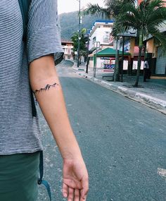 a person with a tattoo on their arm walking down the street