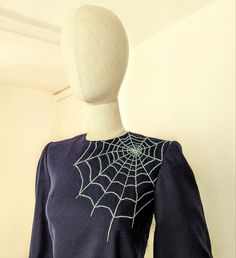 a mannequin's head wearing a spider web t - shirt