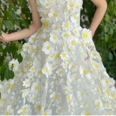 a woman in a white dress with yellow flowers on it