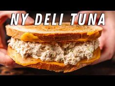 someone holding a sandwich in their hands with the words ny deli tuna on it