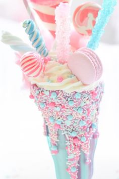 an ice cream sundae with candy and candies on the top is decorated in pastel colors