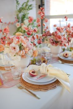 the table is set with peaches and flowers