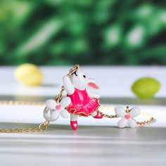 How cute is this pink bunny rabbit necklace accented with cultured pearls and white enamel flowers? Spring is in the air every day with this beautiful necklace, perfect for Easter gifting and hand enamelled, set on an gold plated sterling silver necklace. The ideal accessory to kick off your Spring, Summer look.Carat Weight: 1.5 ctStone Size: 6 mmNumber of Stones: 1 Stone Color: Diamond WhiteStone Shape: RoundWeight: 4.9 gWidth: 16 mmHeight: 23 mmThickness: 7.7 mmMaterial: 925 SilverPlating Colo Whimsical White Pendant Necklace, Whimsical White Pendant Jewelry, Charming Pink Pendant Necklace, Whimsical White Jewelry For Valentine's Day, Pink Jewelry For Easter Gift, Rabbit Necklace, Enamel Flowers, Rabbit Necklaces, Spring Is In The Air