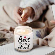 a candle with the words best friends forever written on it next to a coffee cup