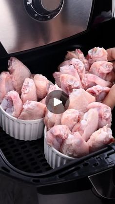 two pans filled with chicken sitting on top of an air fryer