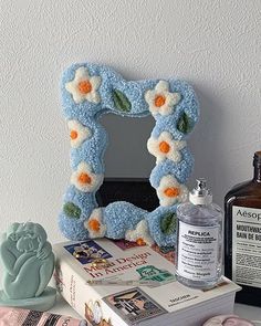 a table topped with books and bottles filled with crafting supplies next to a mirror