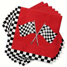 four red napkins with black and white checkered flags on them, one is folded to the side