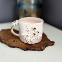 a white coffee cup sitting on top of a wooden tray