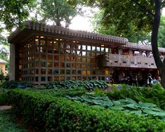 a building with lots of windows sitting in the middle of a lush green park