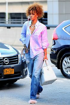 a woman is walking down the street talking on her cell phone and carrying shopping bags