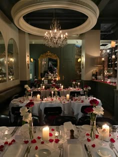 a fancy dining room with candles and flowers on the tables