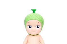 a small doll with a green hat on it's head and eyes, sitting in front of a white background