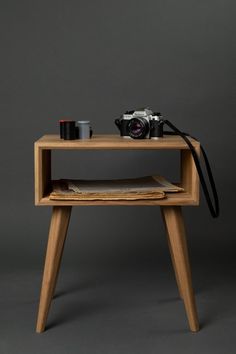 a small wooden table with a camera on it