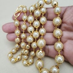 Handmade with Semi precious pearl from India. Beautiful round shape accented with gold filled net on pearl beads. Finished with a gold plated chain and clasp. Length of necklace: 24 inches A BLEND OF TREND AND TRADITION' Comes in a gift box and free shipping in the US. Pearl Chain Necklace With Round Beads, Pearl Beaded Chain Necklace, Gold Beaded Necklaces With Pearl Drop, Gold Beaded Necklace With Pearl Drop, Gold Pearl Drop Necklace For Celebration, Traditional Single Strand Gold Necklace, Gold Pearl Necklace For Celebrations, Traditional Gold Single Strand Necklace, Gold Beads For Long Necklace Party