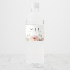 a bottle of water sitting on top of a marble counter with the word mii printed on it