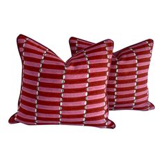 two red and white striped pillows sitting next to each other