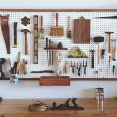 there are many tools on the pegboard and in front of it is a tool holder