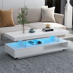 a white coffee table with blue light under it on a carpeted floor next to a couch