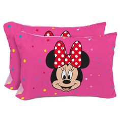 two pink pillows with minnie mouse faces and polka dots on the pillowcase, one has a red bow