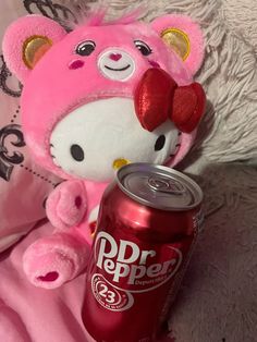 a pink teddy bear next to a dr pepper can