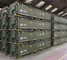 several stacks of green storage containers in a warehouse