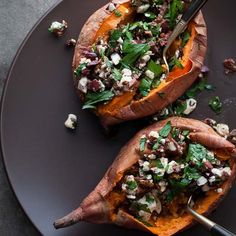 two stuffed sweet potatoes on a black plate