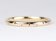 a gold wedding band with stars on it