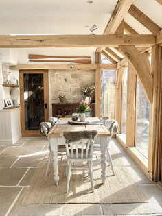 a dining room with wooden beams and white chairs