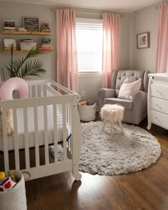 a baby's room with a white crib and pink curtains