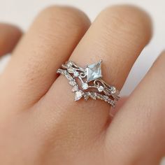 a woman's hand with a ring on top of it and an arrow shaped diamond in the middle