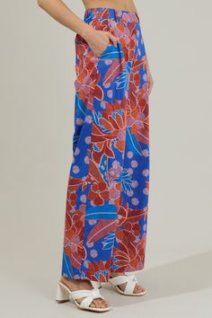 The Amazonia Blue Floral Mulvane Wide Leg Pants are here to show you keep you relaxed and in style! It shapes a high waist with a hidden zip fly and top button closure. It also has a stretchy waist on the back and pockets on each side. Pair this up with the matching top to complete the look!- Side pockets- High waist- Wide leg- Hook and clasp- Color: Blue RedSize + Fit - Model is 5'8" and wearing size XS- Measurements taken from size S - Waist: 14"- Inseam: 30 1/2" Fabric Self:100%Cotton Style N Blue Beach Pants For Spring, Vacation Bottoms With Elastic Waistband In Blue, Blue Elastic Waistband Bottoms For Vacation, Blue Relaxed Fit Beach Bottoms, Blue Beach Bottoms With Elastic Waistband, Blue Elastic Waistband Beach Bottoms, Blue Wide Leg Pants With Relaxed Fit, High Waist Blue Bottoms For Vacation, Blue Wide Leg Pants With Elastic Waistband, Relaxed Fit