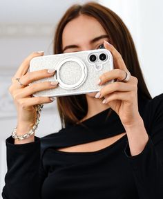 a woman taking a selfie with her cell phone in front of her face and holding it up to the camera