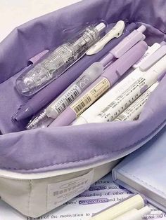 a purple bag filled with lots of different types of pens and writing instruments in it