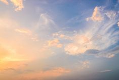 an airplane flying in the sky with clouds above it at sunset or sunrise time,