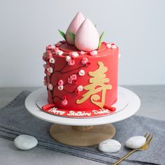 there is a red cake with flowers on the top and chinese writing on the bottom