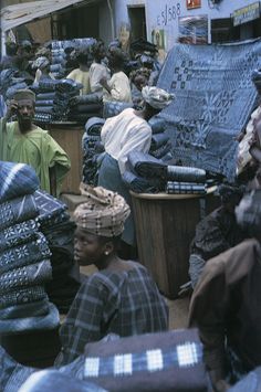 a group of people standing around piles of blankets